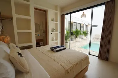 a bedroom with a bed with a view of a pool at 5 min to Finns Beach Club & Trendy Hotspot in Canggu