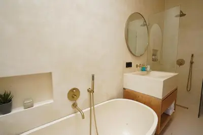 a bathroom with a tub and a sink and a mirror at 5 min to Finns Beach Club & Trendy Hotspot in Canggu