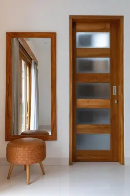 a mirror and a stool in front of a door at Villa Sunshyne in Seminyak