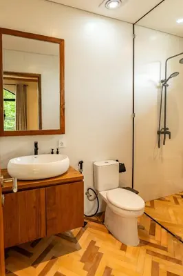 a bathroom with a toilet and a sink and a mirror at Tuluscoliving villa kuta 2, 4 Bedroom & 5 Bathroom in Ngurah Rai International Airport