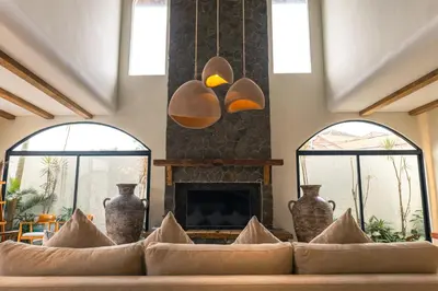 a living room with two windows and a fireplace at Tuluscoliving villa kuta 2, 4 Bedroom & 5 Bathroom in Ngurah Rai International Airport