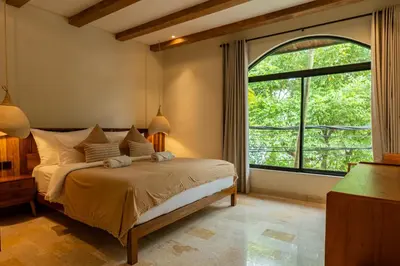 a bedroom with a bed and a large window at Tuluscoliving villa kuta 2, 4 Bedroom & 5 Bathroom in Ngurah Rai International Airport