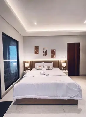 a bedroom with a large white bed and a large window at Villa Jasmine in Seminyak