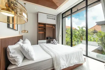 a bedroom with a large bed and a large window at Coastal Chic 5BR Luxury Villa Canggu Beachside in Canggu