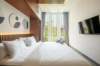 a bedroom with a large white bed with a window at Coastal Chic 5BR Luxury Villa Canggu Beachside in Canggu