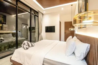 a bedroom with a large white bed with a window at Coastal Chic 5BR Luxury Villa Canggu Beachside in Canggu