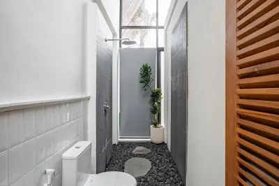 a bathroom with a white toilet and a window at 2BR Villa in Canggu, Villa Sejiwa 3 in Canggu