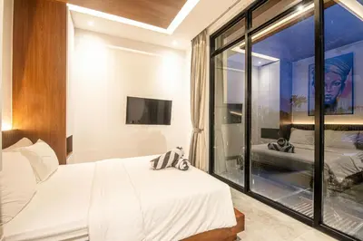 a bedroom with a bed and a large window at Hidden Paradise 5BR Canggu Gem Near Waves in Canggu
