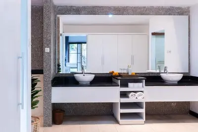 a bathroom with two sinks and a large mirror at Karen's Tropical Villa in Seminyak