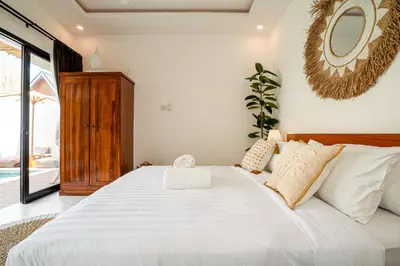 a bedroom with a large white bed with a mirror at Cozy 2BR Villa Nara with Private Pool and Fitness Corner in Seminyak -Bali in Seminyak