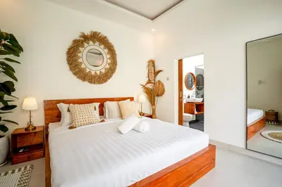 a bedroom with a large white bed with a mirror at Cozy 2BR Villa Nara with Private Pool and Fitness Corner in Seminyak -Bali in Seminyak