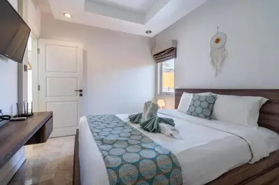 a bedroom with a large bed and a television at Villa Azure 2 - Private Pool Villa near Seminyak Centre in Seminyak