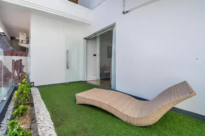 a living room with a rattan couch and grass at Villa Azure 2 - Private Pool Villa near Seminyak Centre in Seminyak