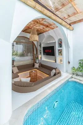 a living room with a swimming pool and a tv at Villa MAVI Seminyak in Seminyak