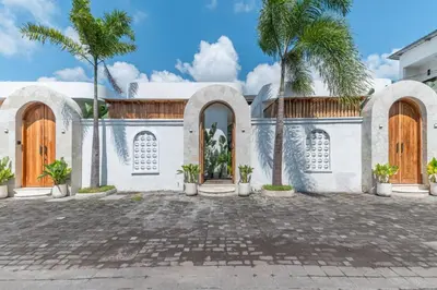 a house with palm trees in the driveway at Villa MAVI Seminyak in Seminyak