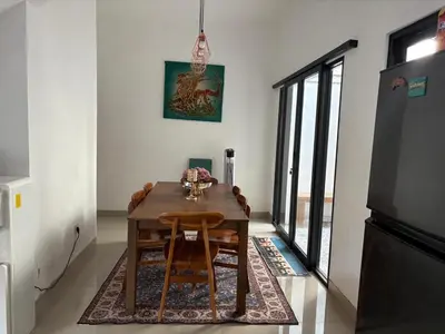 a dining room with a wooden table and chairs at Villa Rumah Lemon Nusa Dua in Nusa Dua