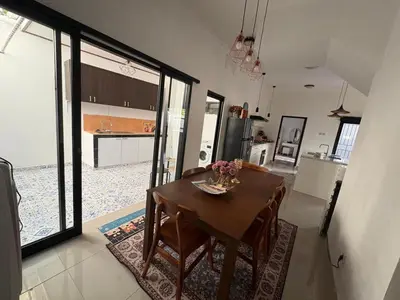 a kitchen and dining room with a table with flowers on it at Villa Rumah Lemon Nusa Dua in Nusa Dua