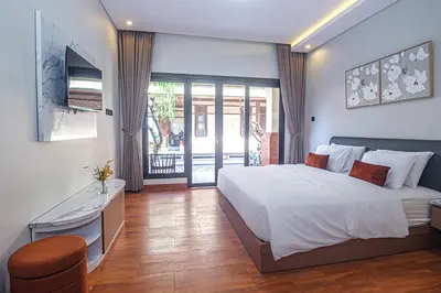 a bedroom with a large bed and a balcony at The Hunian in Seminyak