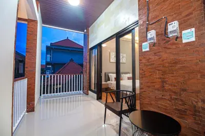 a balcony with a table and a brick wall at The Hunian in Seminyak