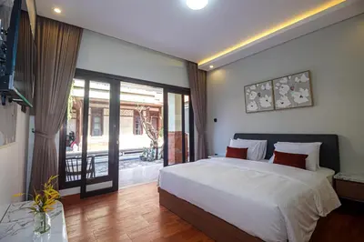 a bedroom with a large bed and a sliding glass door at The Hunian in Seminyak