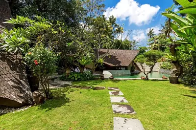 a garden of a house with a grass yard at Kalyca Seminyak 4 Bedroom in Seminyak