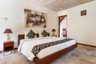 a bedroom with a large bed and a window at Kalyca Seminyak 4 Bedroom in Seminyak