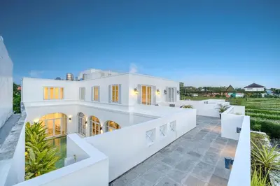 a large white house with a courtyard at Colonial Style 3BR Walking Distance to the Beach in Canggu