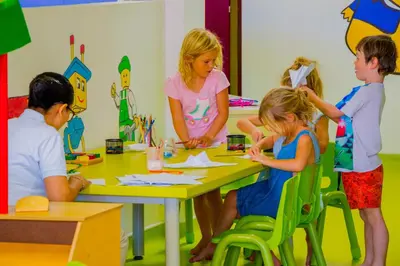a group of children sitting around a table making crafts at Montigo Resorts Seminyak in Seminyak