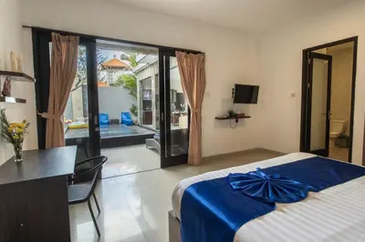 a bedroom with a bed and a desk and a window at Taman Bali Villa Kerobokan 2 in Kerobokan
