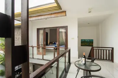 a room with a balcony with a table and chairs at Taman Bali Villa Kerobokan 2 in Kerobokan