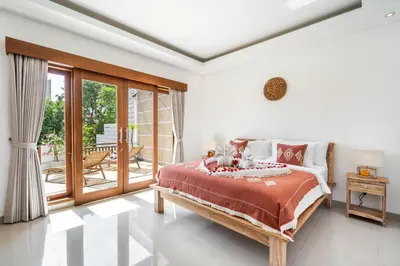 a bedroom with a bed and a balcony at Villa Avaluna by JB Villas in Seminyak