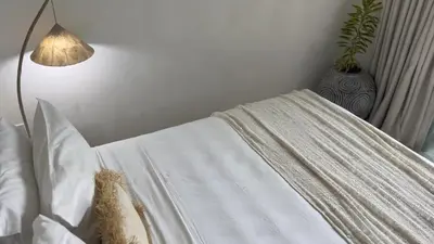 a bed with a white blanket and a lamp at Villa Marabia - Charming Quiet 3BR in Seminyak in Seminyak