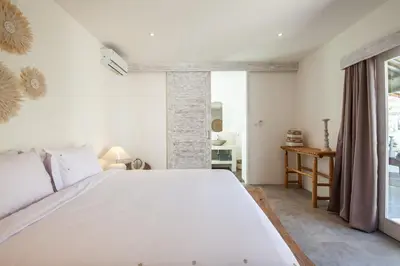 a bedroom with a large white bed and a window at New 5 bedroom Villa close to Seminyak eat street in Seminyak