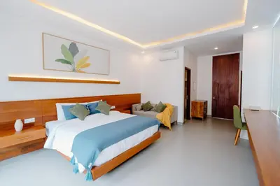 a bedroom with a large bed and a desk at Kania Rooms & Suite in Seminyak
