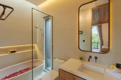 a bathroom with a tub and a sink and a mirror at Vin Villa Kerobokan 2BR with Private Pool in Kerobokan