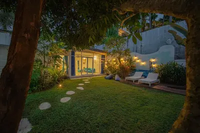 a backyard at night with a couch and a table at Casa Sopi - Art Villa 2BR Near Batu Belig Beach in Seminyak