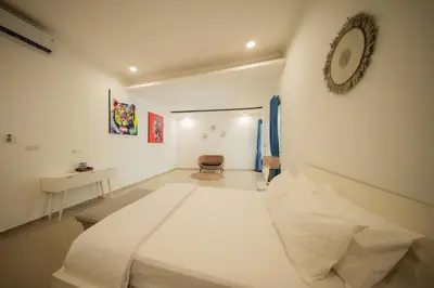a bedroom with a large white bed in a room at Casa Sopi - Art Villa 2BR Near Batu Belig Beach in Seminyak