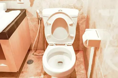 a bathroom with a toilet with the lid up at First Home Stay in Ngurah Rai International Airport