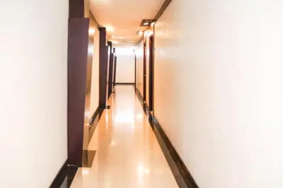 a hallway with a long corridor with wooden floors at First Home Stay in Ngurah Rai International Airport
