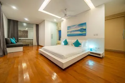 a large bedroom with a bed and a couch at Villa Aquila in Seminyak