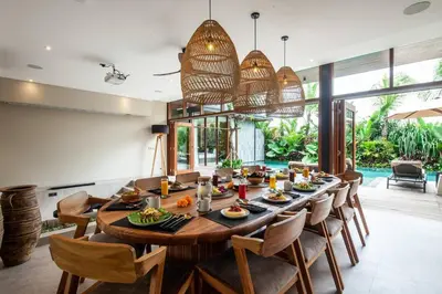 a dining room with a large wooden table and chairs at Luxury 6BR villa Berawa beach in Canggu