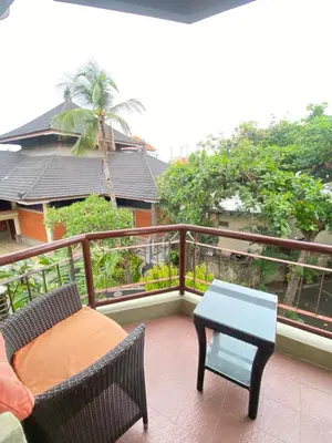 a patio with a table and chairs on a balcony at The Coastal Apartment at Jayakarta Residence in Seminyak