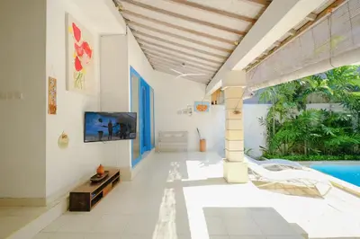 a living room with a tv and a swimming pool at Beji Ayu Seminyak - 1 Bedroom Private Villa in Seminyak