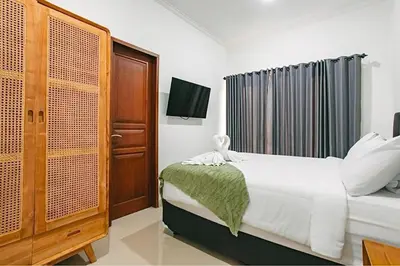 a bedroom with a bed and a television in it at Nice Villa In Seminyak #YoNa in Seminyak