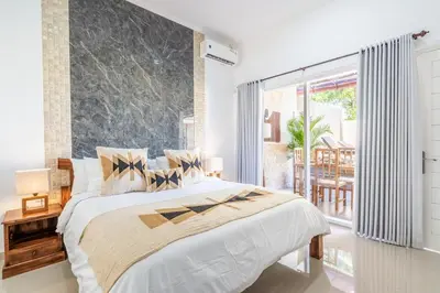 a bedroom with a large bed and a large window at RK3, 2 beds villa 15 min walk to Double Six Beach in Seminyak