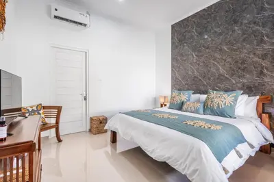 a bedroom with a bed with a large stone wall at RK3, 2 beds villa 15 min walk to Double Six Beach in Seminyak