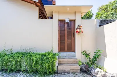 a white house with a wooden door and stairs at RK3, 2 beds villa 15 min walk to Double Six Beach in Seminyak