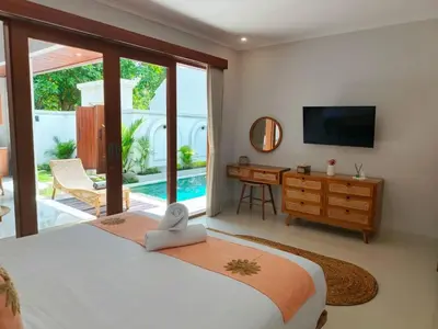 a bedroom with a bed and a desk and a television at RK4 Brand New 2Bedroom Villa Near Seminyak in Seminyak