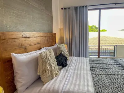 a bedroom with a bed with pillows and a window at RK5, 2 beds villa 15 min walk to Double Six Beach in Seminyak