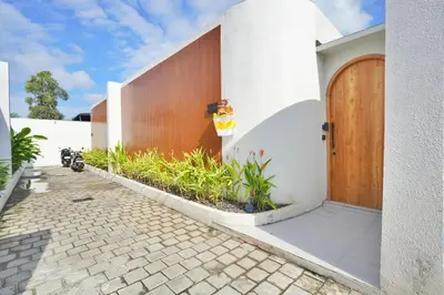a house with a wooden door on the side of it at Bright, Airy & Private, your 2BR Bali Escape in Seminyak